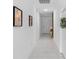 Bright hallway featuring tile flooring, a decorative wreath, modern wall art, and a view towards the front door at 663 Fairview Ave, Haines City, FL 33844