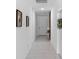 Bright hallway with tile flooring, neutral paint, decorative wall art, and a clear view to the front door at 663 Fairview Ave, Haines City, FL 33844