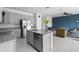 Modern kitchen with a granite island and stainless steel appliances flowing into the living room at 663 Fairview Ave, Haines City, FL 33844