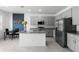 Charming kitchen with an island and a stainless steel refrigerator, microwave, oven, and grey cabinets at 663 Fairview Ave, Haines City, FL 33844