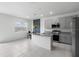 Open kitchen has tile floors, gray cabinets, granite countertops, and a center island at 663 Fairview Ave, Haines City, FL 33844