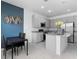 Kitchen with stainless steel appliances, an island with granite countertop, and grey cabinets at 663 Fairview Ave, Haines City, FL 33844
