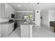 Bright kitchen featuring gray cabinetry, a granite island, and stainless steel appliances at 663 Fairview Ave, Haines City, FL 33844