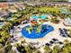 Overhead view showcases the water park and pool amenities within the community, surrounded by lush landscaping and homes at 7419 Marker Ave, Kissimmee, FL 34747