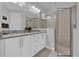 Bright bathroom with a granite-topped double vanity, a walk-in shower with a glass door, and tile flooring at 7419 Marker Ave, Kissimmee, FL 34747