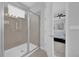 Modern bathroom featuring a glass enclosed shower, neutral tile, and a view of the main bedroom at 7419 Marker Ave, Kissimmee, FL 34747