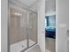 Modern bathroom featuring a glass enclosed shower, neutral tile, and access to the bedroom at 7419 Marker Ave, Kissimmee, FL 34747