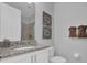 Clean bathroom featuring a granite sink and vanity, a mirror, decor, and a commode at 7419 Marker Ave, Kissimmee, FL 34747