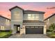 Two-story home showcases a gray facade, stone accents, and a paved driveway leading to a two-car garage at 7419 Marker Ave, Kissimmee, FL 34747