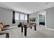 Spacious game room with foosball table, sofa, media, and natural light from the three windows at 7419 Marker Ave, Kissimmee, FL 34747