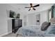 Comfortable bedroom featuring a ceiling fan, tv and ample storage in the black chest of drawers at 7419 Marker Ave, Kissimmee, FL 34747