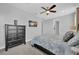 Comfortable bedroom featuring a ceiling fan, tv and ample storage in the black chest of drawers at 7419 Marker Ave, Kissimmee, FL 34747