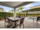 Covered outdoor patio featuring a dining table, lounge chairs, and a private plunge pool at 7419 Marker Ave, Kissimmee, FL 34747
