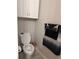 Toilet area with a grey towel hanging and white cabinets above the toilet at 860 N Orange Ave # 470, Orlando, FL 32801