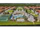 Wide aerial view of the community amenities with pool, tennis, well-manicured landscaping, and residences at 8990 Cuban Palm Rd, Kissimmee, FL 34747