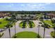 Panoramic aerial view of the community clubhouse, pool area, tennis courts, and surrounding landscape at 8990 Cuban Palm Rd, Kissimmee, FL 34747