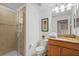 Bathroom featuring a walk-in shower, granite vanity, a toilet, and neutral-toned tile at 8990 Cuban Palm Rd, Kissimmee, FL 34747