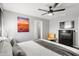 Bedroom with a TV, sunset wall art, ceiling fan, gray walls, and a decorative chair at 8990 Cuban Palm Rd, Kissimmee, FL 34747