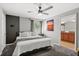 Modern bedroom with a ceiling fan, gray walls, a decorative wall, and a view into the bathroom at 8990 Cuban Palm Rd, Kissimmee, FL 34747