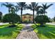 Elegant community clubhouse entrance with manicured landscaping and a welcoming brick pathway at 8990 Cuban Palm Rd, Kissimmee, FL 34747