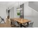 Dining room with a long table, six chairs, and modern light fixture at 8990 Cuban Palm Rd, Kissimmee, FL 34747