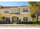 Inviting townhome featuring a red tile roof, arched entry, and tidy landscaping at 8990 Cuban Palm Rd, Kissimmee, FL 34747