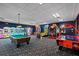 Vibrant game room with a pool table, air hockey, and various arcade games, perfect for Gathering fun at 8990 Cuban Palm Rd, Kissimmee, FL 34747