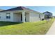 Backyard view of home with green grass, stucco, and covered porch at 1003 Cascade Dr, Davenport, FL 33837