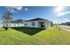 Backyard view of home with lush green grass and covered patio at 1003 Cascade Dr, Davenport, FL 33837