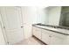 Bathroom featuring double vanity with granite countertop, large mirror, and tile flooring at 1003 Cascade Dr, Davenport, FL 33837