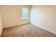 A cozy bedroom is brightened by a window with white blinds, while offering neutral carpeting at 1003 Cascade Dr, Davenport, FL 33837