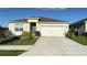 Charming single-story home features a well-manicured lawn, two-car garage, and a blue front door at 1003 Cascade Dr, Davenport, FL 33837