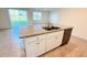Kitchen island with granite countertop, stainless steel sink, dishwasher, and white cabinets at 1003 Cascade Dr, Davenport, FL 33837