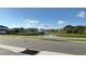 Picturesque street view of pond and houses in the background beneath a blue, cloudy sky at 1003 Cascade Dr, Davenport, FL 33837