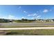 A scenic street view shows a pond with homes in the background under a blue, cloudy sky at 1003 Cascade Dr, Davenport, FL 33837