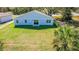 A well-maintained lawn and a blue single-story home are featured in this backyard, with glass sliding doors at 102 Sail Way, Kissimmee, FL 34759