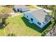 Aerial view of backyard featuring lush green grass, patio, and the home's light gray exterior at 102 Sail Way, Kissimmee, FL 34759