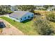 Aerial view of a blue single-story home featuring a well-maintained lawn and patio in the backyard at 102 Sail Way, Kissimmee, FL 34759