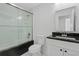 A bathroom featuring a glass shower, a vanity with black countertop, and a sleek mirror at 102 Sail Way, Kissimmee, FL 34759