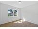 A bright, carpeted bedroom featuring a window with natural light offering relaxing views of neighborhood trees at 102 Sail Way, Kissimmee, FL 34759