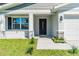Inviting front porch and entryway with decorative stonework and modern black door at 102 Sail Way, Kissimmee, FL 34759