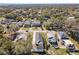 A high-angle aerial view shows the neighborhood streets and nearby homes with mature trees and green lawns at 1112 W Line St, Leesburg, FL 34748