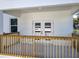 A covered back porch with light wood railings leads to the home's entrance via glass paneled double doors at 1112 W Line St, Leesburg, FL 34748