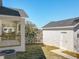 The home's backyard features the back porch on one building and the detached garage, separated by grass at 1112 W Line St, Leesburg, FL 34748