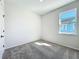 Well-lit bedroom with neutral carpet and a window providing natural light and neighborhood views at 1112 W Line St, Leesburg, FL 34748