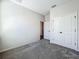 Bedroom featuring neutral carpeting, a closet with double doors, and an adjacent doorway at 1112 W Line St, Leesburg, FL 34748