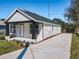 Newly renovated single story home with a freshly poured driveway, well maintained yard and black and white accents at 1112 W Line St, Leesburg, FL 34748