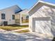 Bright, white home exterior with a covered porch featuring wooden railings, plus a detached garage with a white door at 1112 W Line St, Leesburg, FL 34748