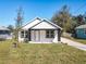 Charming single-story home with a classic white facade, black accents, and a freshly landscaped front yard at 1112 W Line St, Leesburg, FL 34748