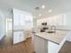Bright kitchen with white cabinets, stainless steel appliances, light countertop, and light vinyl floors at 1112 W Line St, Leesburg, FL 34748